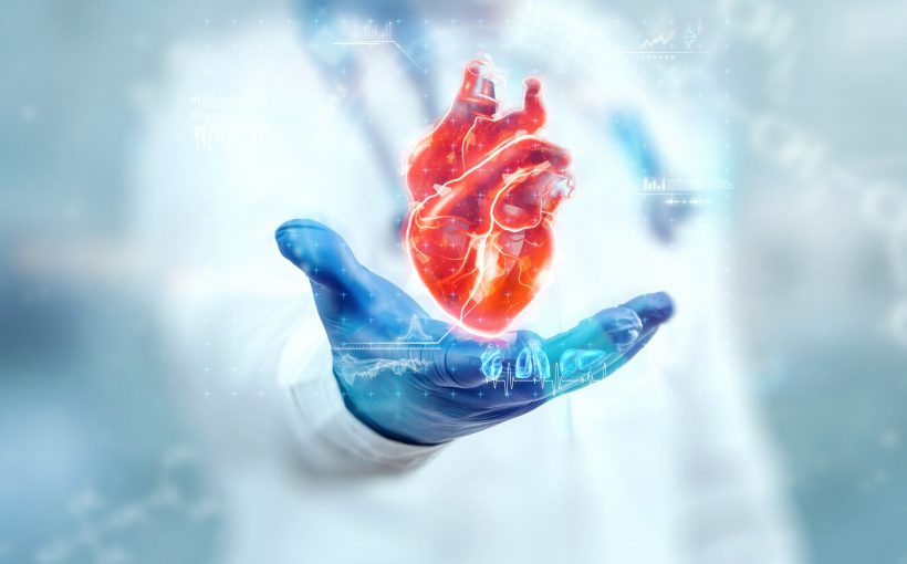 Lekarz ubrany w fartuch medyczny wyciąga dłoń nad którą pokazane jest serce. /Źródło: 123rf.com