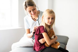 Młoda lekarka bada stetoskopem plecy dziewczynki w celu diagnostyki chorób. /Źródło: 123rf.com