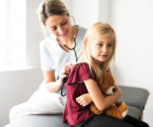 Młoda lekarka bada stetoskopem plecy dziewczynki w celu diagnostyki chorób. /Źródło: 123rf.com