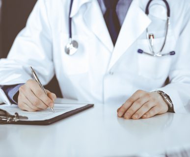 Lekarz internista przeprowadza konsultacje lekarską, wypełnia zaświadczenie. /Źródło: 123rf.com