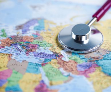 Kolorowa mapa świata, na której położony jest lekarski stetoskop. /Źródło: 123rf.com