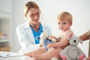 Doświadczona lekarka-pediatra osłuchuje małe dziecko za pomocą stetoskopu. /Źródło: 123rf.com