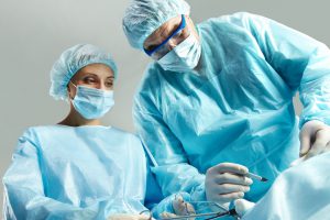 Lekarz chirurg wraz z pielęgniarką przeprowadza zabieg chirurgiczny w sterylnych warunkach. /Źródło: 123rf.com