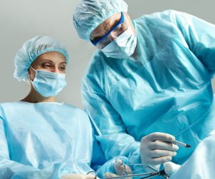 Lekarz chirurg wraz z pielęgniarką przeprowadza zabieg chirurgiczny w sterylnych warunkach. /Źródło: 123rf.com