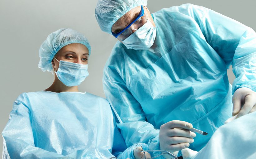 Lekarz chirurg wraz z pielęgniarką przeprowadza zabieg chirurgiczny w sterylnych warunkach. /Źródło: 123rf.com