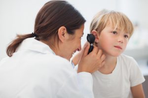 Lekarka laryngolożka bada dziecku uszy za pomocą otoskopu. /Źródło: 123rf.com