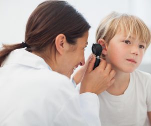 Lekarka laryngolożka bada dziecku uszy za pomocą otoskopu. /Źródło: 123rf.com