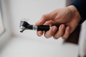 Lekarz laryngolog trzyma w dłoni narzędzie medyczne jakim jest otoskop. /Źródło: 123rf.com