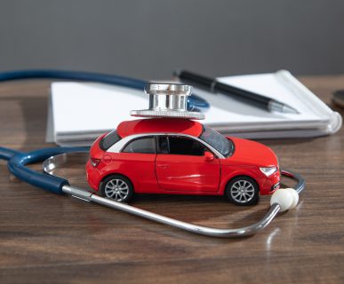 Biurko lekarza orzecznika, na którym położone jest czerwone auto i stetoskop. /Źródło: 123rf.com
