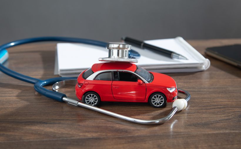 Biurko lekarza orzecznika, na którym położone jest czerwone auto i stetoskop. /Źródło: 123rf.com