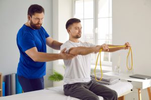 Fizjoterapeuta przeprowadza z pacjentem zabiegi i ćwiczenia fizykoterapeutyczne. /Źródło: 123rf.com