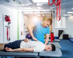 Fizjoterapeuta robi masaż pleców pacjentowi podczas rehabilitacji. /Źródło: 123rf.com