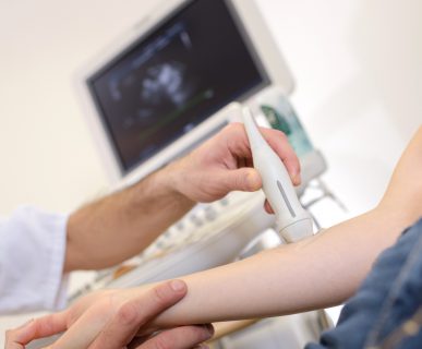 Doświadczony lekarz wykonuje pacjentowi badanie USG doppler za pomocą profesjonalnego sprzętu medycznego. /Źródło: 123rf.com