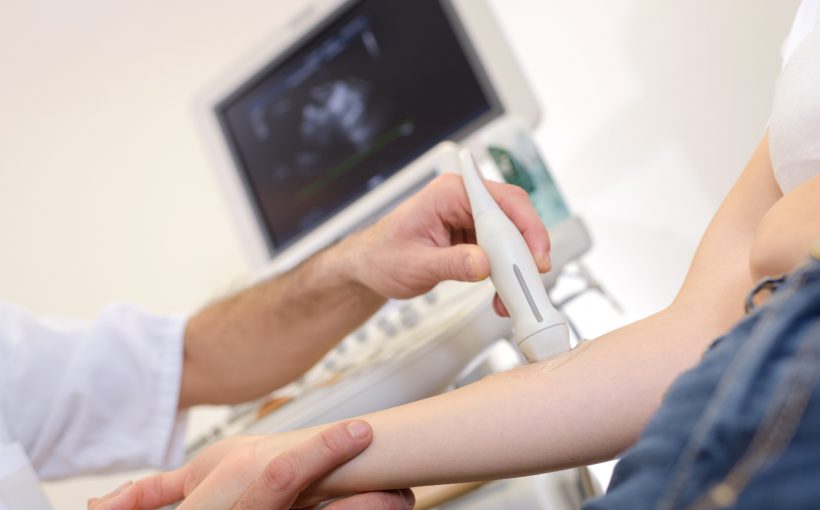Doświadczony lekarz wykonuje pacjentowi badanie USG doppler za pomocą profesjonalnego sprzętu medycznego. /Źródło: 123rf.com