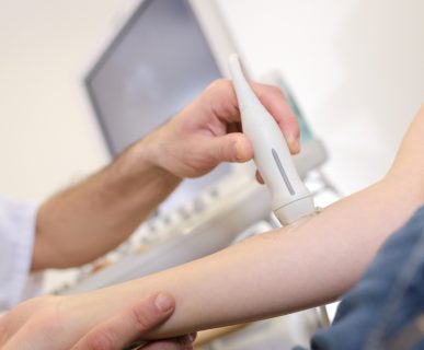 Lekarz przeprowadza pacjentowi badanie diagnostyczne jakim jest USG doppler żył i tętnic. /Źródło: 123rf.com