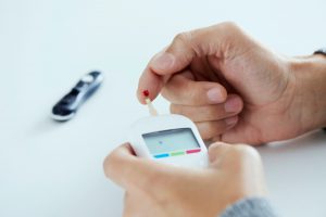 Pacjent mierzy glukometrem poziom cukru we krwi z opuszki palca. /Źródło: 123rf.com