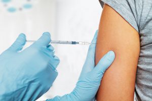 Lekarz szczepi pacjentkę szczepionką przeciwko WZW A. /Źródło: 123rf.com