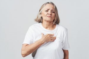 Kobieta trzyma się za klatkę piersiową, bo źle się czuje przez menopauzę. /Źródło: 123rf.com