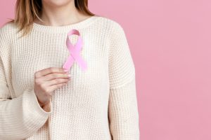 Kobieta trzyma różową wstęgę na znak solidarności z kobietami chorującymi na nowotwór. /Źródło: 123rf.com