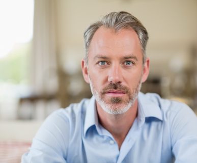 Mężczyzna po czterdziestce, z siwiejącymi włosami i brodą w niebieskiej koszuli. /Źródło: 123rf.com