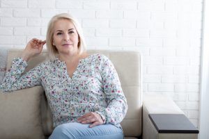 Dojrzała kobieta siedzi na kanapie w poczekalni u lekarza. /Źródło: 123rf.com