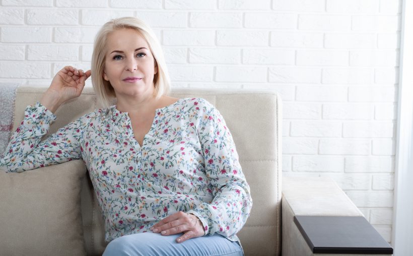 Dojrzała kobieta siedzi na kanapie w poczekalni u lekarza. /Źródło: 123rf.com