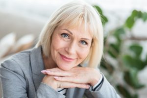 Kobieta po pięćdziesiątym roku życia uśmiecha się do aparatu. /Źródło: 123rf.com