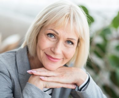 Kobieta po pięćdziesiątym roku życia uśmiecha się do aparatu. /Źródło: 123rf.com