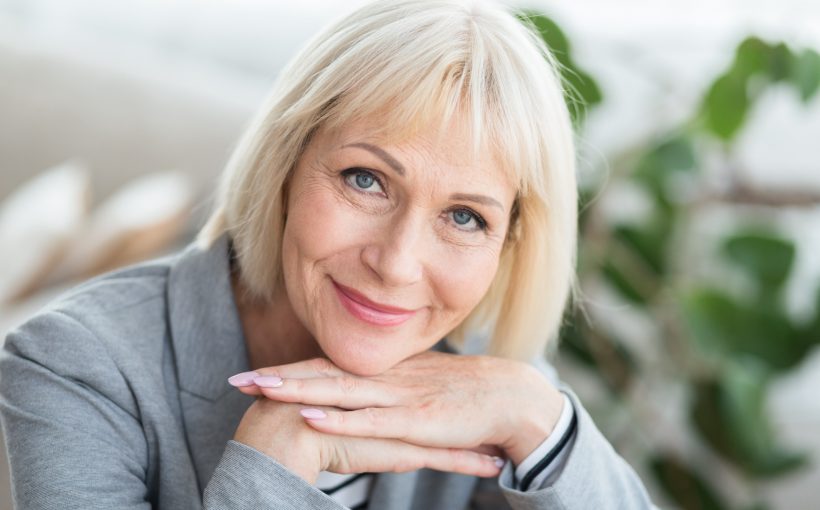 Kobieta po pięćdziesiątym roku życia uśmiecha się do aparatu. /Źródło: 123rf.com