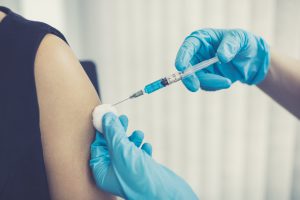 Lekarz szczepi pacjentkę szczepionką przeciw WZW A. /Źródło: 123rf.com