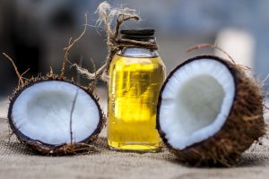 Olejek kokosowy w fiolce, obok młodych kokosów. /Źródło: 123rf.com