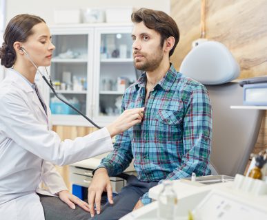 Lekarka osłuchuje stetoskopem młodego mężczyznę, w celu diagnostyki i leczenia. /Źródło: 123rf.com