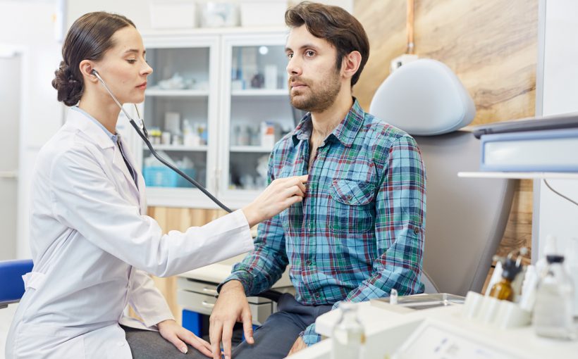 Lekarka osłuchuje stetoskopem młodego mężczyznę, w celu diagnostyki i leczenia. /Źródło: 123rf.com