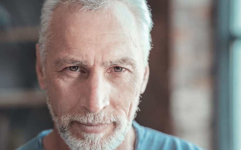 Starszy, zadbany mężczyzna z siwymi włosami patrzy w obiektyw. /Źródło: 123rf.com