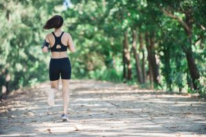 Kobieta w stroju sportowym  uprawia jogging w zalesionym parku. /Źródło: 123rf.com