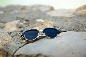 Eleganckie okulary przeciwsłoneczne położone na kamieniu. /Źródło: 123rf.com