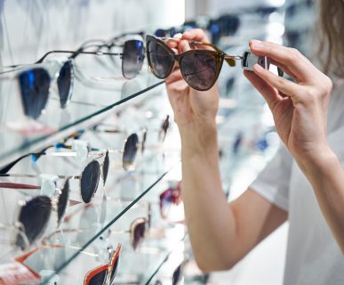 Młoda kobieta wybiera okulary słoneczne w salonie optycznym. /Źródło: 123rf.com