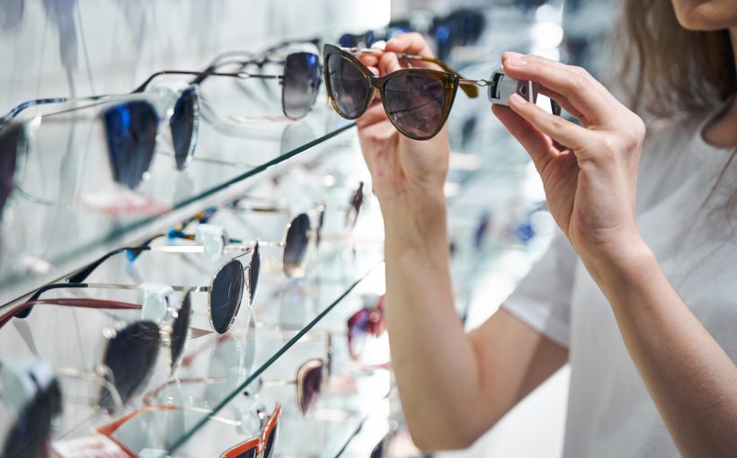 Młoda kobieta wybiera okulary słoneczne w salonie optycznym. /Źródło: 123rf.com