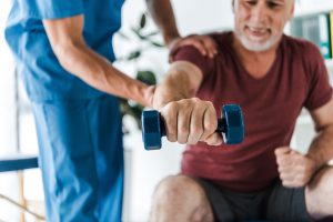Fizjoterapeuta ćwiczy z pacjentem podczas rehabilitacji. /Źródło: 123rf.com