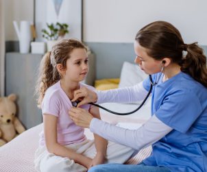 Młoda lekarka osłuchuje dziewczynce organy za pomocą stetoskopu. /Źródło: 123rf.com