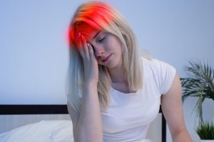 Dziewczyna z migreną trzyma się za głowę. /Źródło: 123rf.com