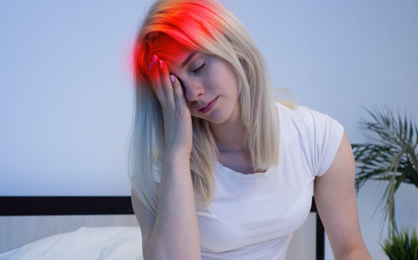 Dziewczyna z migreną trzyma się za głowę. /Źródło: 123rf.com