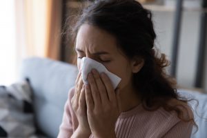 Kobieta wydmuchuje nos w chusteczkę. /Źródło: 123rf.com