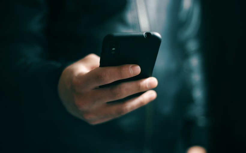Mężczyzna sprawdza wiadomość SMS na telefonie. /Źródło: 123rf.com