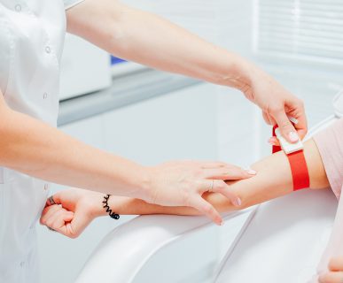 Pielęgniarka pobiera próbkę krwi od pacjenta z żyły u ręki. Źródło: 123rf.com