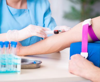 Pielęgniarka ubrana w sterylny, medyczny strój pobiera krew pacjentowi w celu diagnostyki i analizy laboratoryjnej. Źródło 123rf.com