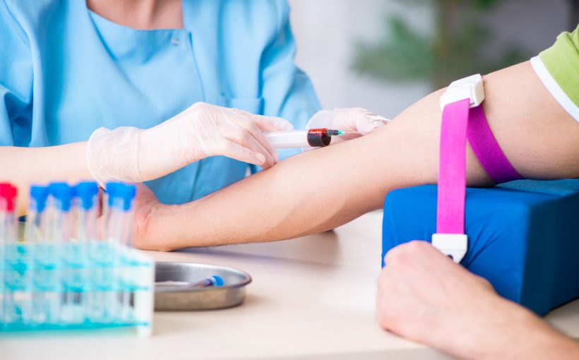 Pielęgniarka ubrana w sterylny, medyczny strój pobiera krew pacjentowi w celu diagnostyki i analizy laboratoryjnej. Źródło 123rf.com