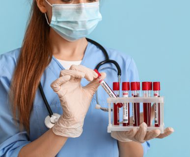 Pielęgniarka odziana w medyczny strój trzyma w dłoniach probówki wypełnione krwią pacjentów do celów dalszej diagnostyki laboratoryjnej. Źródło: 123rf.com