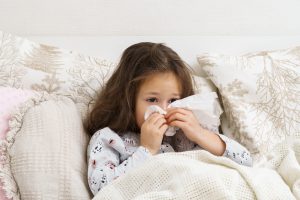 Dziewczynka smarka w chusteczkę. /Źródło: 123rf.com