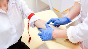 Pielęgniarz pobiera pacjentowi krew z żyły u ręki w sterylnych warunkach. Źródło: 123rf.com